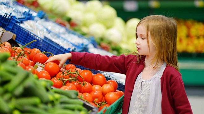 girl_choosing_tomatoes_in_supermarket